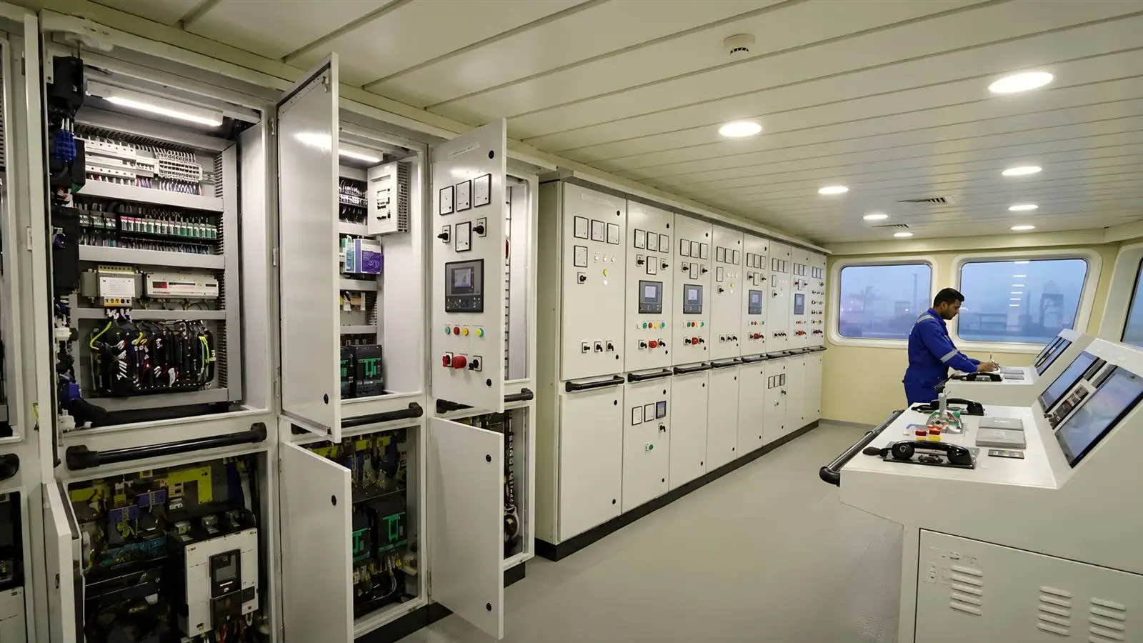 Marine switchboard room with panels open for inspection aboard a vessel